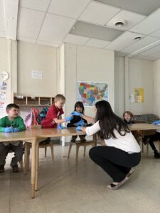 Children are interacting with a volunteer at the Coddington Road Community Center 